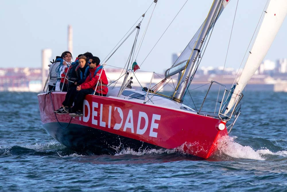 Crianças a aprender a velejar, a bordo de um barco à vela no rio Tejo, em Lisboa